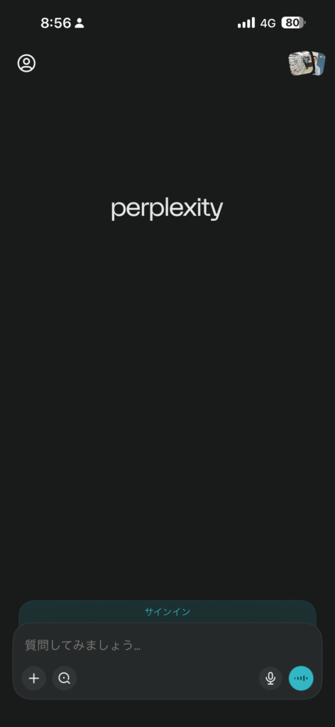 * Perplexityのスマホアプリ版（iOS/Android）の起動画面。移動中でも片手で操作できるシンプルなインターフェース。画面下部には、歩きながらリサーチ可能な「音声入力ボタン」が配置されている。